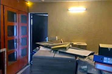 La pièce servait de réserve : portes en bois d'origine, mobilier démonté empilé contre le mur.